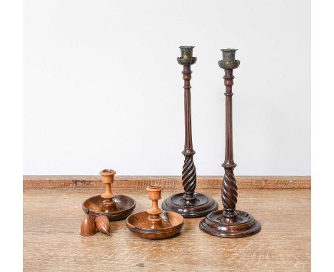 A Pair of George III Carved and Turned Mahogany Candlesticks, with brass petal formed sconces, reeded tapering pedestals and 