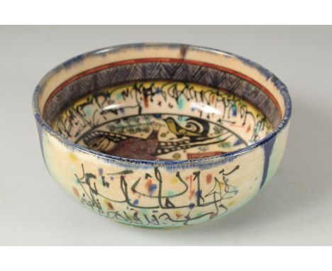 A VINTAGE KHOROSAN STYLE GLAZED POTTERY BOWL, painted with a figure and calligraphy, 21cm diameter.