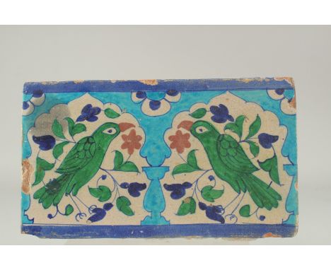 A LARGE EARLY 19TH CENTURY NORTH INDIAN MULTAN GLAZED POTTERY TILE, depicting two birds mihrab design, 30cm x 18cm.
