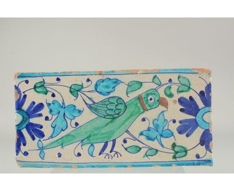 AN EARLY 19TH CENTURY NORTH INDIAN MULTAN GLAZED POTTERY TILE, painted with a parrot, 30.5cm x 15cm.