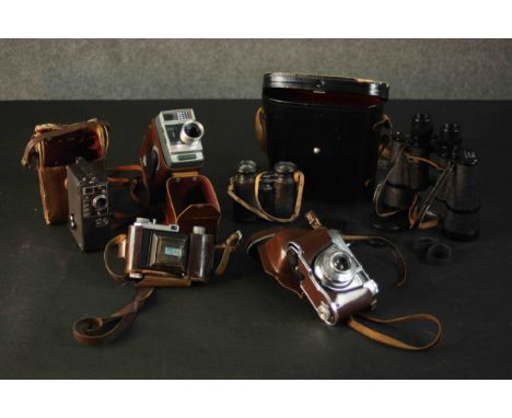 A collection of four vintage cameras. A Kodak Retinette 1A, Kodak Automatic 8, and two pairs of binoculars. 8mm /16mm /35mm. 