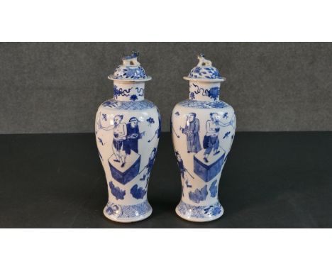 A pair of 19th century Chinese blue and white hand painted porcelain vases and covers. The lidded jars each of baluster form 