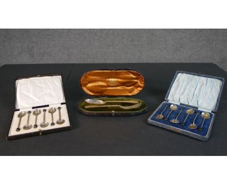 A collection of silver spoons, including two boxed sets of six silver coffee spoons with coffee bean finials and a leather ca