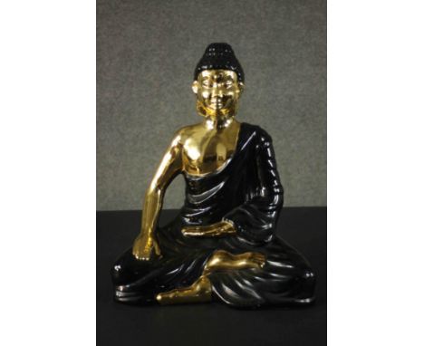 A large ceramic black and gold Buddha figure. H.45 W.35 D.21cm. 