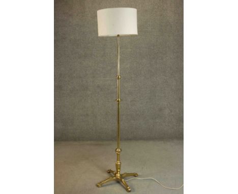 An Arts and Crafts brass floor lamp with a four prong base and floral motifs. H.192cm. 