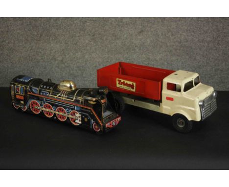 A vintage Tri-ang tipper truck and a similar tinplate locomotive. H.15 W.39 D.12cm. (largest) 
