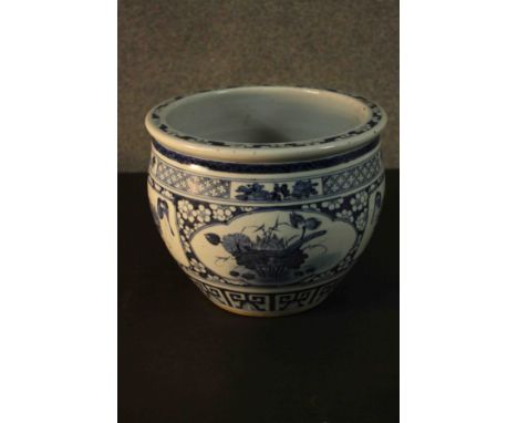 A 19th century Chinese blue and white hand painted ceramic planter. Decorated with panels each showing a different flower wit