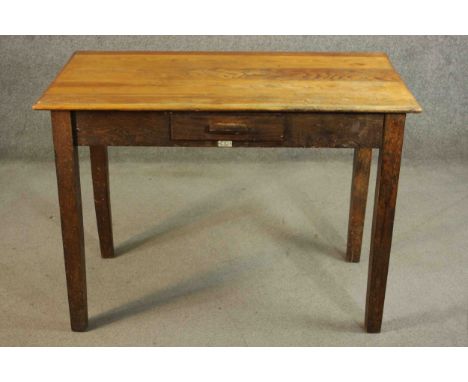 A vintage oak writing table with frieze drawer and maker's label on square supports. H.76 W105 D.59cm. 