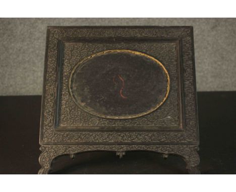 An Anglo-Indian ebonised carved easel picture frame with floral design and oval cartouche to centre. H.30 W.30cm. 