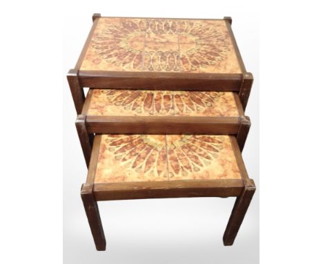 A 20th-century nest of three teak tile-topped tables, width 60cm.