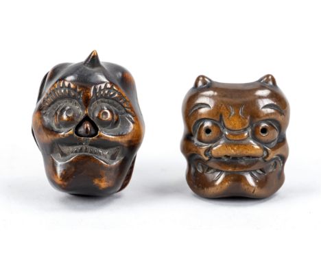 2 Netsuke, Japan, wohl 19. Jh. (Edo/Meiji), Hartholz. Dämonenmasken, 1 x mit beweglicher Nase. Leicht ber., D. bis 4,5 cm