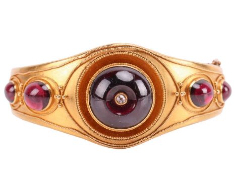 A Victorian Etruscan Revival hinged bangle set with garnet and diamond, collet-set with five graduated garnet cabochons, wher