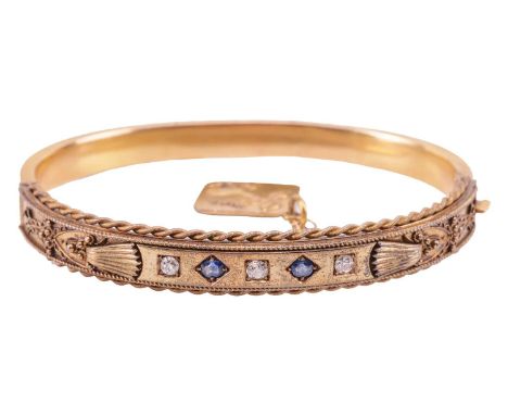 A Victorian gem-set hinged bangle, with one half of Etruscan revival design, featuring wirework detailing and set with two sa