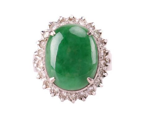 A jade and diamond halo ring, comprising an oval jadeite cabochon of deep green colour, approximately measures 15.0 x 11.9 x 