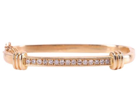 A diamond-set hinged bangle in 14ct gold, constructed of two slightly angular halves, decorated with fluted roundels and pavé