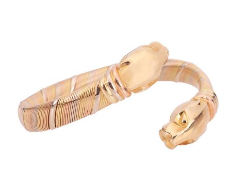 Cartier - a Panthère cuff bracelet in 18ct tricoloured gold, sprung bangle with panther head terminations, signed and numbere