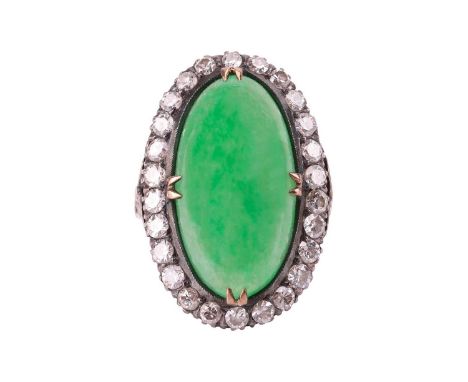 A jade and diamond halo ring, featuring an elongated oval jadeite cabochon of yellowish-green colour, approximately measuring