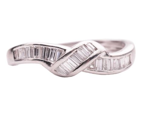 A diamond-set dress ring of knot design, channel-set with an array of baguette-cut diamonds, to a tapering shank, white metal