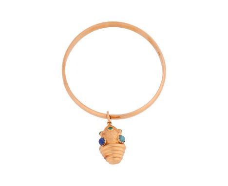 A closed bangle with a gem-set charm, of ovoid shape with half fluted, set with round glass beads and engraved with undulatin