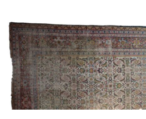 A NORTH WEST PERSIAN COUNTRY HOUSE CARPET, the rectangular ivory field containing serrated leaves, conjoined flowerheads and 