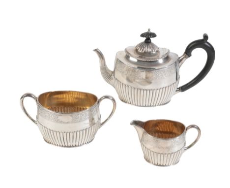 A LATE VICTORIAN SILVER THREE PIECE TEA SERVICE, London 1890, the tea pot with a half gadrooned body, a chased foliate band w