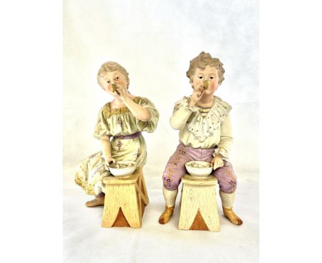A pair of bisque figures, young girl & young boy smoking a pipe Height 35 cm