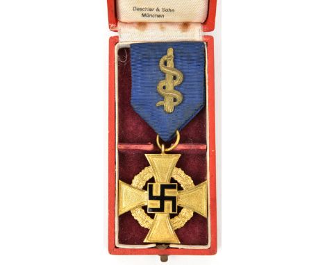 A Third Reich 1st class Faithful Service Decoration, in gilt and enamel, with ribbon, which has a brass medical symbol (? sna
