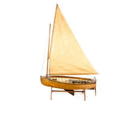 A model of a Victorian/Edwardian style sailing boat. A single masted wooden clinker built teak model with open hull, fore mou