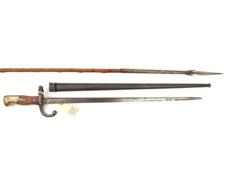 A Gras bayonet, d 1873 on backstrap, in scabbard (dark rust patina), and an African fishing spear, opposing barbed head, slen