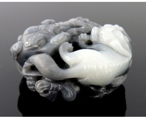 A Chinese black and white jade pendant carving, in the form of large and small shi-shi, diameter 5cm 