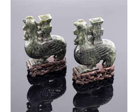 A pair of oriental spinach jade spill vases, in the form of stylized cockerels in two dimensional form, height 16.5cm, on woo