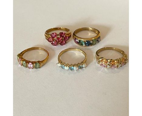 A collection of five 9ct yellow gold gem set rings. To include an opal and apatite set dress ring, and multi-coloured sapphir