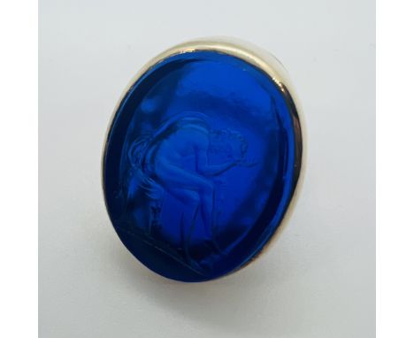 A 19th century moulded paste intaglio seal set into a 1960s cocktail ring mount.  Depicting an ancient Greek man , holding a 