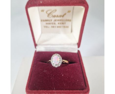 A 9ct gold opal and diamond cluster ring.&nbsp; Featuring a central opal cabochon, measuring approximately 8mm x 5mm, surroun