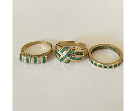 Collection Of three emerald set dress rings. Featuring a "9K" stamped emerald set eternity ring, size Q; a 9ct emerald set cr