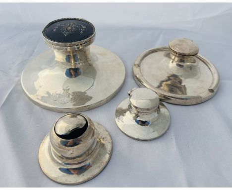 A group of four sterling silver weighted inkwells. Featuring a circular inkwell with a pique work tortoiseshell lid, with an 