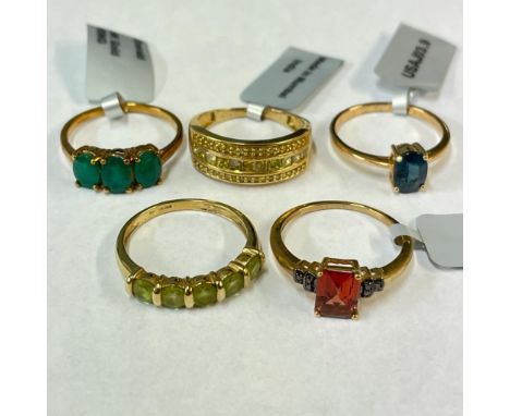 A yellow diamond cluster ring in 9ct yellow gold, along with an emerald trilogy ring, a garnet and red diamond ring and two f