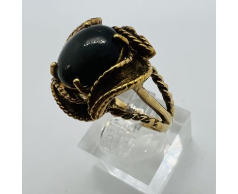 A black cabochon set 1970s style cocktail ring, Stamped "10K" and tests accordingly. Size N. Approximate gross weight 6.2gram