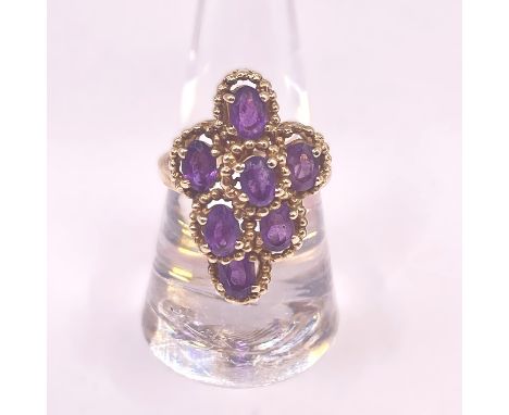 A 9ct gold Amethyst cocktail cluster ring.&nbsp; Featuring seven oval mixed cut amethysts each measuring approximately 7mm x 