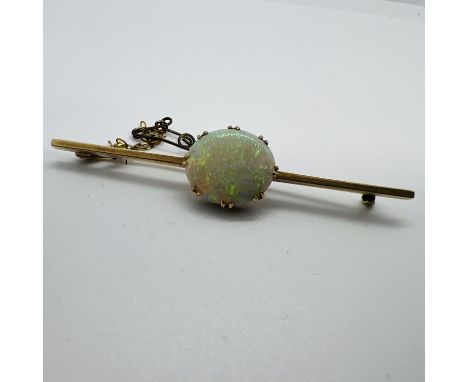 An early 20th century bar brooch set with a large opal. The opal is en cabachon and measures 15mm x 12mm face up. The stone h