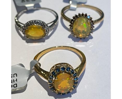 Three Ethiopian opal 9ct gold dress rings Featuring an opal and red diamond ring; an "east to west" set opal and diamond ring