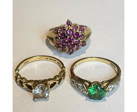 A group of three 9ct gold gem set ring. Featuring a purpleish garnet cluster ring and two cubic zirconia set dress rings. Siz