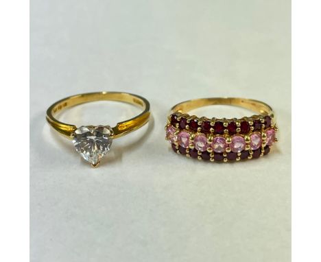 Two 14ct yellow gold gem set rings. Featuring a heart shaped cubic zirconia solitaire ring and a ruby ad pink sapphire dress 