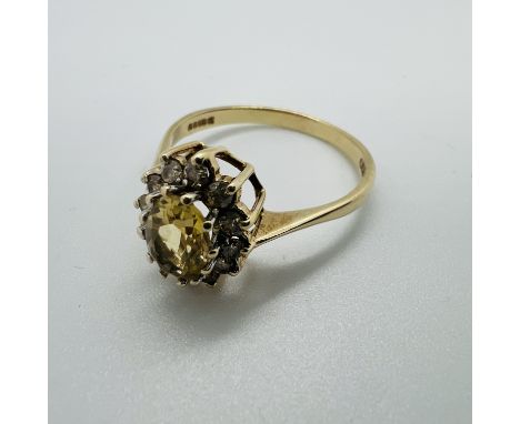 A 9ct gold citrine and diamond cluster ring.&nbsp; Central citrine measuring approximately 7mm x 5mm.&nbsp; Size R.&nbsp; Gro