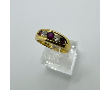 A Victorian 18ct gold ruby and diamond dress ring. Featuring three off round rubies interspersed with two old mine cut diamon