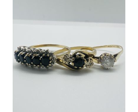 A group of three 9ct yellow gold rings. Featuring a dark sapphire and illusion set diamond trilogy ring, size R1/2; a five st