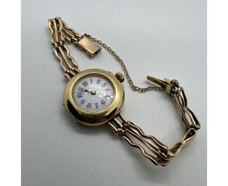 An early 20th century yellow metal watch and bracelet. With a white enamel dial, with Arabic numerals in blue and red, to a k