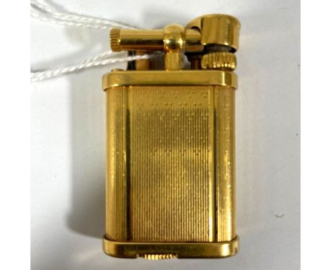A gold plated Dunhill unique gas lighter number 357623.  50mm x 30mm.  Some small dings, has not been tested but generally go