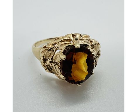 A 9ct gold citrine set cocktail ring, featuring a cognac coloured citrine, measuring approximately 9mm x 7mm, in a raised fol