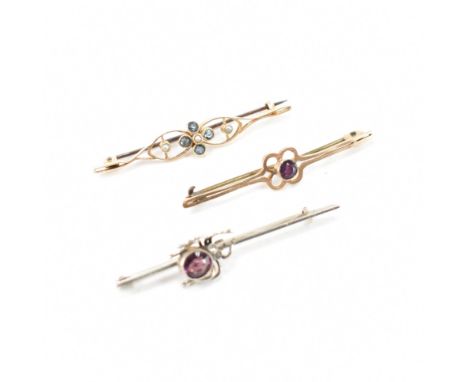 A collection of three bar brooches. The first brooch of 9ct yellow gold with a round cut purple stone set to the centre in a 